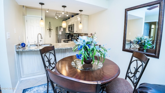 dining space featuring sink and light tile patterned floors