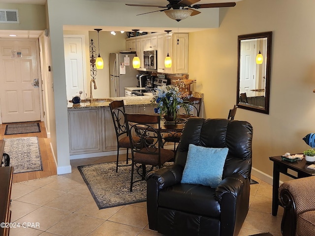 tiled dining area featuring sink and ceiling fan