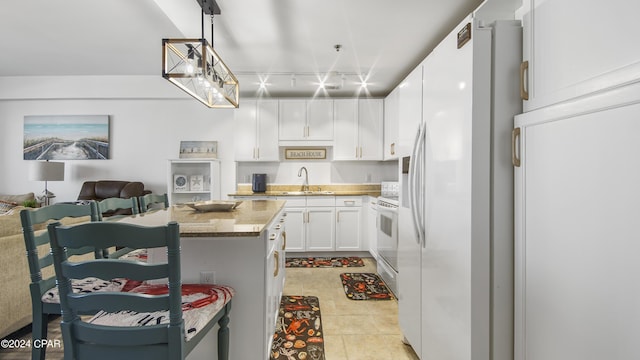 kitchen featuring sink, stone countertops, decorative light fixtures, white appliances, and white cabinets