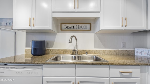 kitchen with dishwasher, sink, white cabinets, and dark stone counters