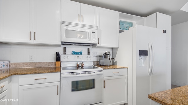 kitchen featuring dark stone counters, white cabinets, and white appliances