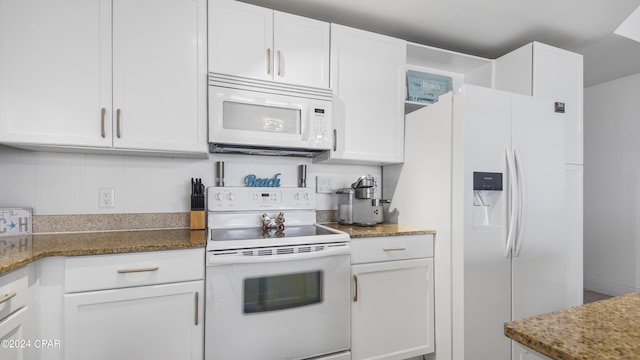 kitchen with white cabinetry, dark stone countertops, and white appliances