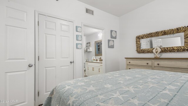 bedroom with ensuite bath, sink, and a closet