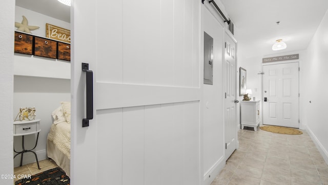 hallway featuring light tile patterned floors and a barn door