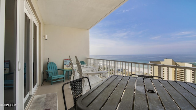 balcony with a water view and a view of the beach