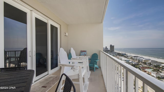 balcony featuring a water view and a beach view