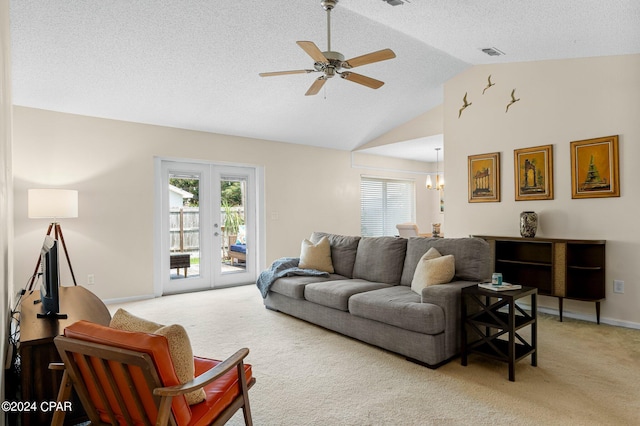 living room featuring ceiling fan with notable chandelier, a textured ceiling, french doors, and light colored carpet