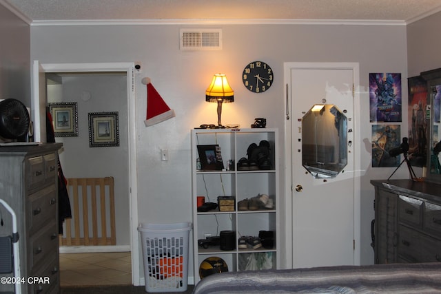 tiled bedroom featuring ornamental molding and a textured ceiling