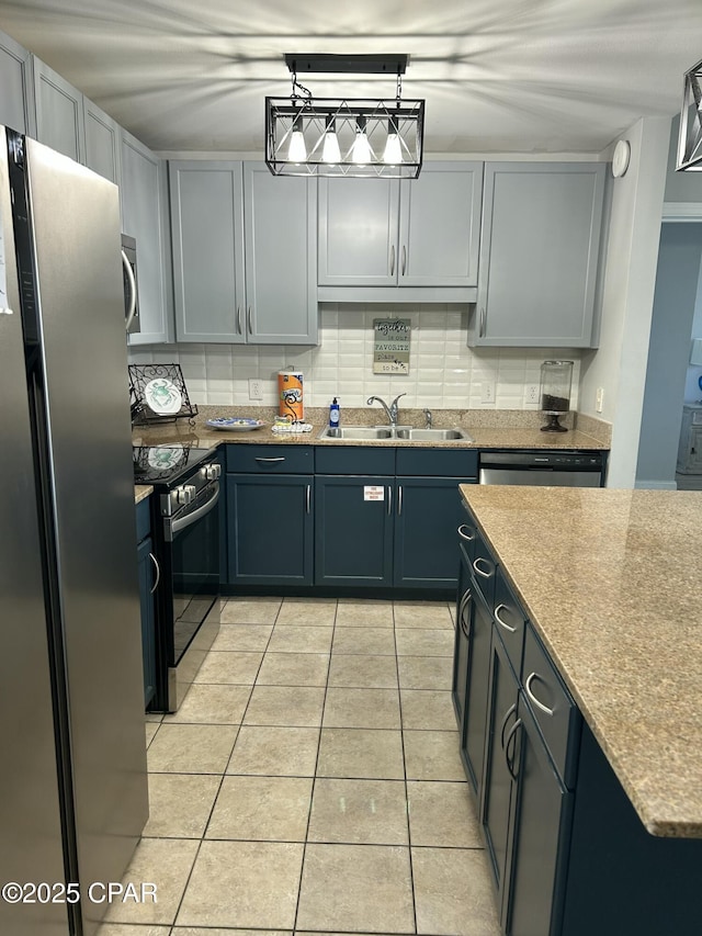 kitchen featuring light tile patterned floors, a sink, stainless steel appliances, backsplash, and pendant lighting