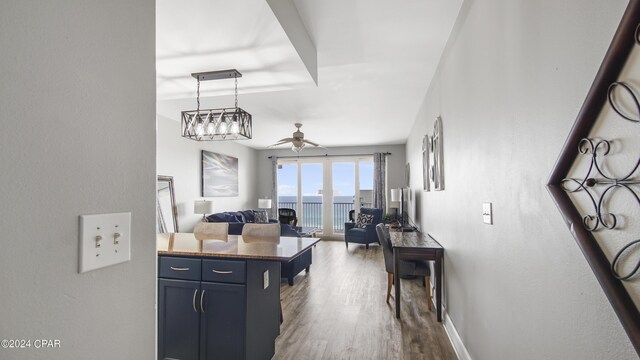 kitchen with pendant lighting, ceiling fan with notable chandelier, and hardwood / wood-style flooring