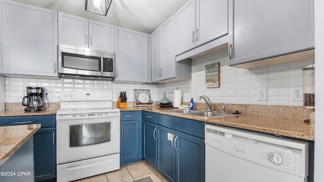 kitchen featuring tasteful backsplash, sink, light tile patterned floors, white appliances, and blue cabinets