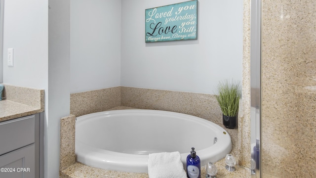 bathroom featuring a garden tub and vanity