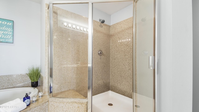 bathroom featuring a stall shower and a garden tub