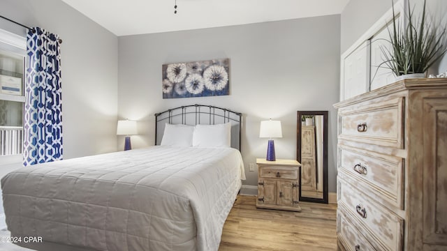 bedroom with light wood-style flooring and baseboards