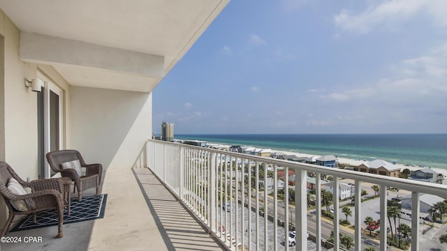 balcony featuring a water view and a beach view