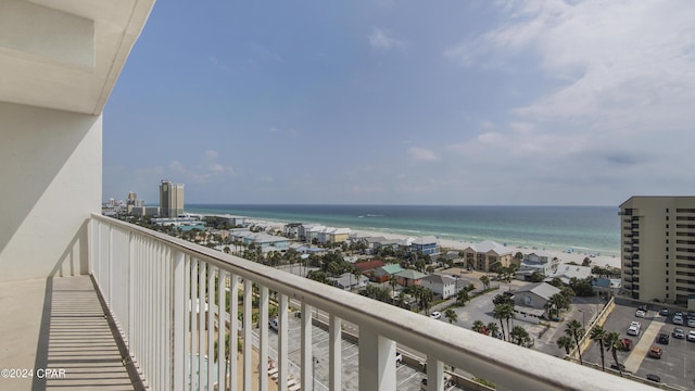 balcony with a water view and a view of the beach