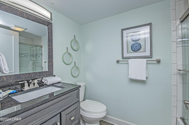 bathroom featuring vanity, toilet, and an enclosed shower