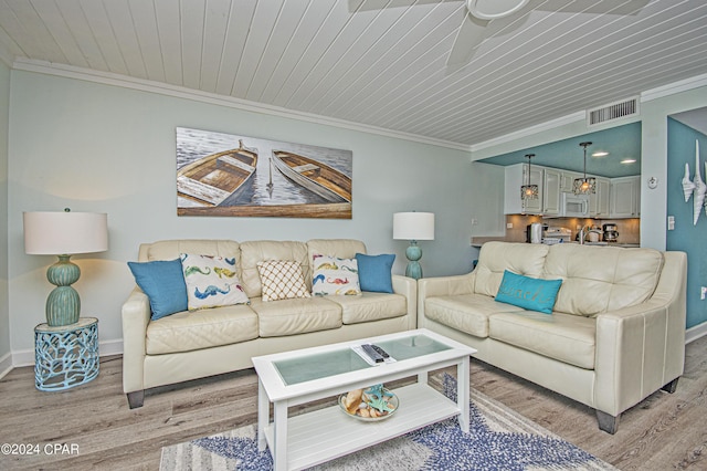 living room with ornamental molding and light hardwood / wood-style floors