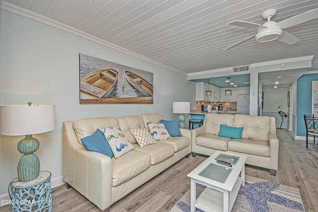 living room featuring ceiling fan, ornamental molding, sink, and light hardwood / wood-style flooring