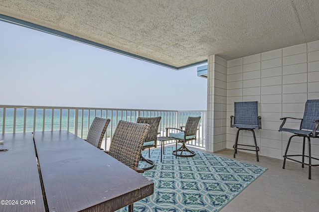 view of patio featuring a balcony and a water view