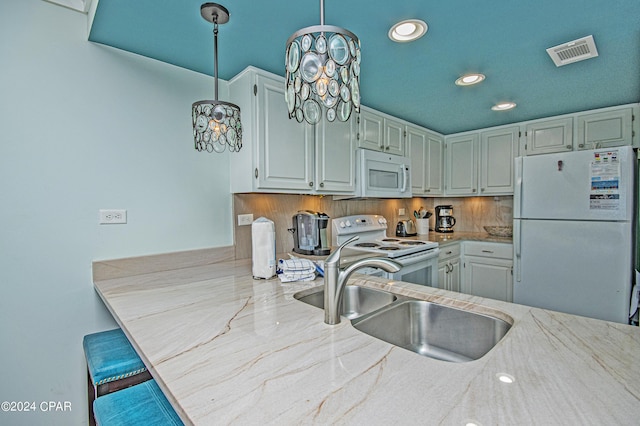 kitchen featuring sink, tasteful backsplash, pendant lighting, white appliances, and light stone countertops