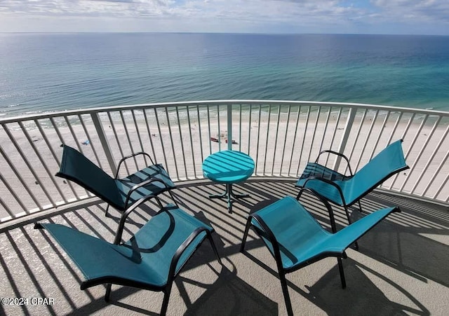 balcony with a water view and a view of the beach