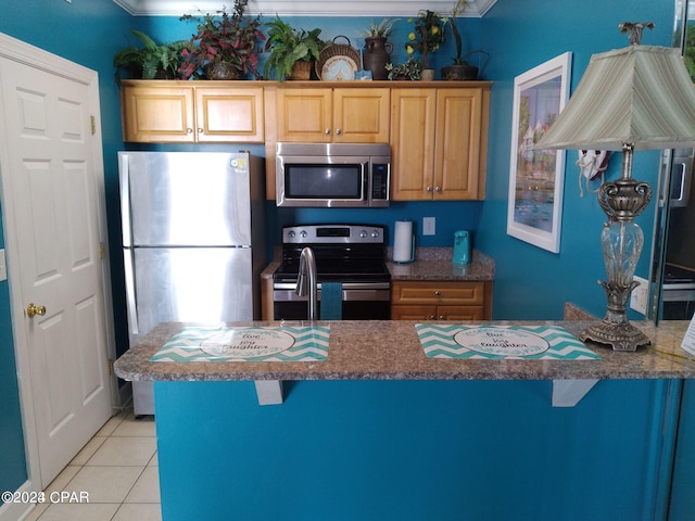 kitchen featuring stainless steel appliances, sink, a breakfast bar area, and light tile patterned floors