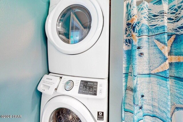 washroom with stacked washing maching and dryer