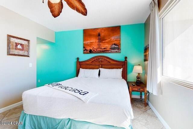 tiled bedroom featuring ceiling fan