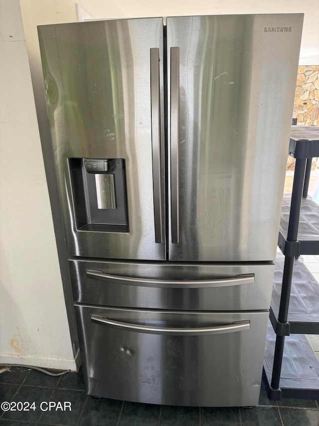 details featuring dark tile patterned floors and stainless steel fridge with ice dispenser