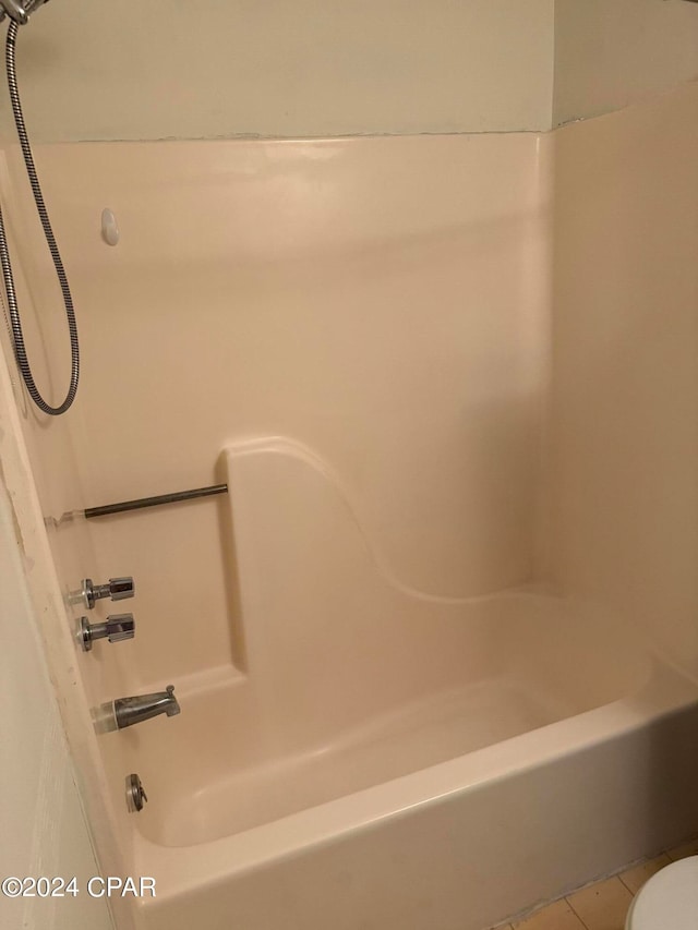 bathroom with tub / shower combination, tile patterned floors, and toilet