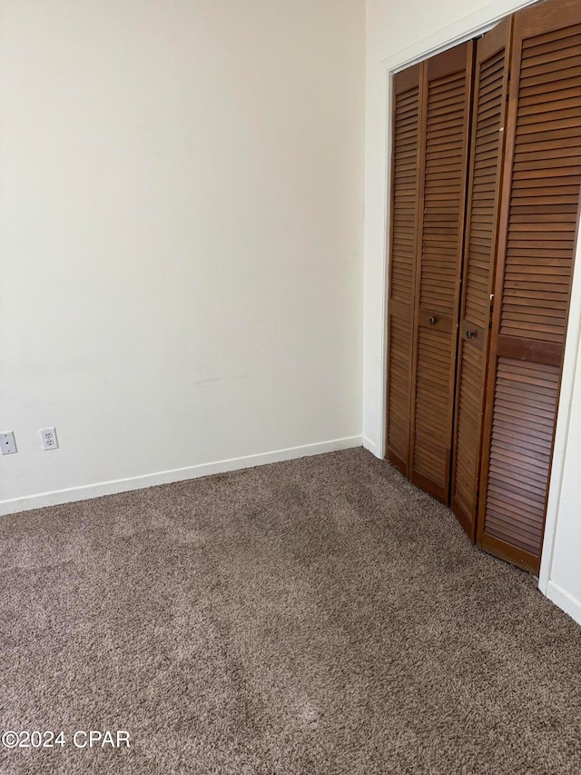 unfurnished bedroom featuring carpet and a closet