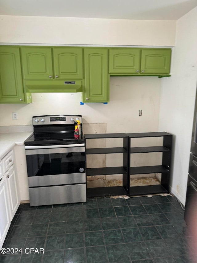 kitchen featuring dark tile patterned flooring, stainless steel range with electric stovetop, and green cabinetry