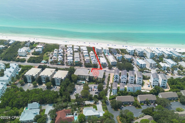 aerial view featuring a view of the beach, a water view, and a residential view