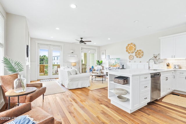 kitchen featuring white cabinets, dishwasher, light countertops, open shelves, and a sink