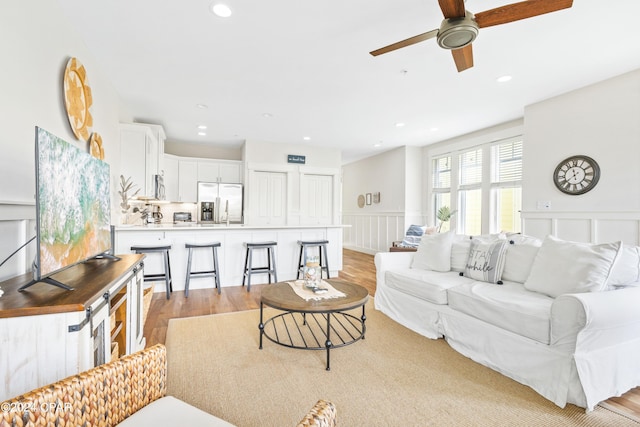 living room featuring a wainscoted wall, light wood-type flooring, and recessed lighting