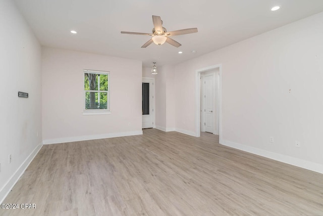 empty room with ceiling fan and light hardwood / wood-style flooring