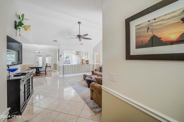 tiled living room with ceiling fan, french doors, and lofted ceiling