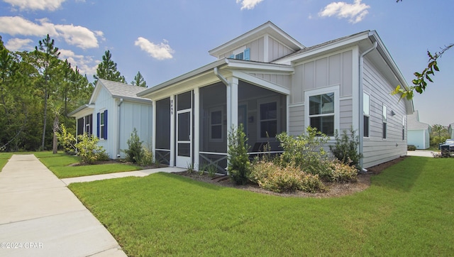 view of side of home with a yard and a sunroom