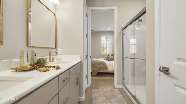 bathroom featuring hardwood / wood-style flooring, vanity, and a shower with door