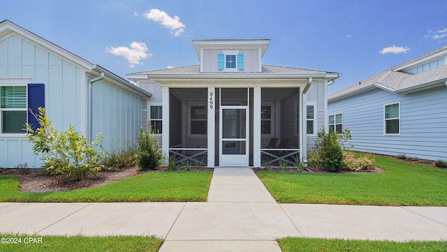 view of front of home featuring a front lawn and a sunroom