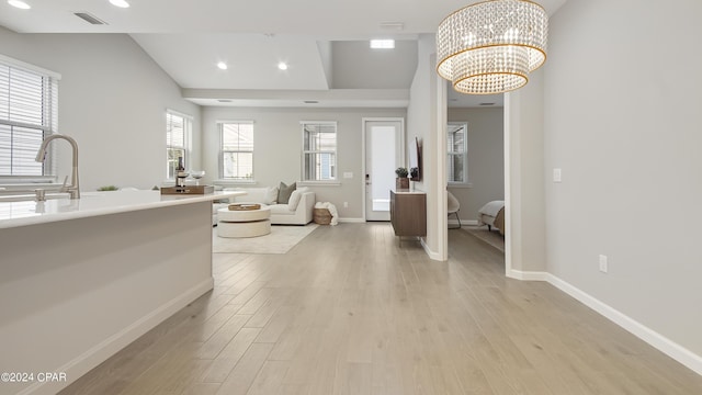 interior space featuring sink, light hardwood / wood-style floors, and a notable chandelier