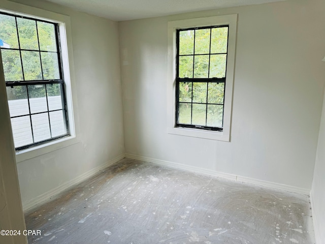 unfurnished room featuring plenty of natural light and a textured ceiling