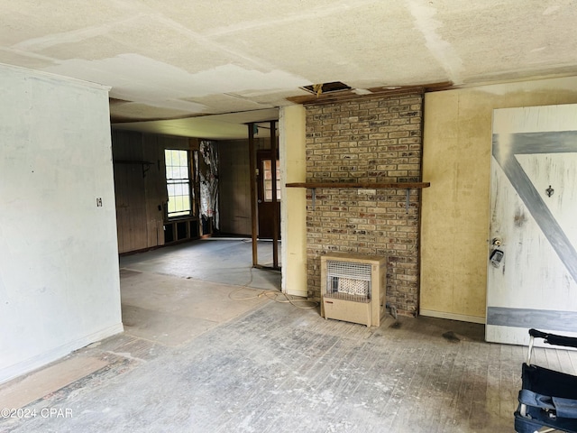 unfurnished living room with a fireplace, a textured ceiling, and brick wall