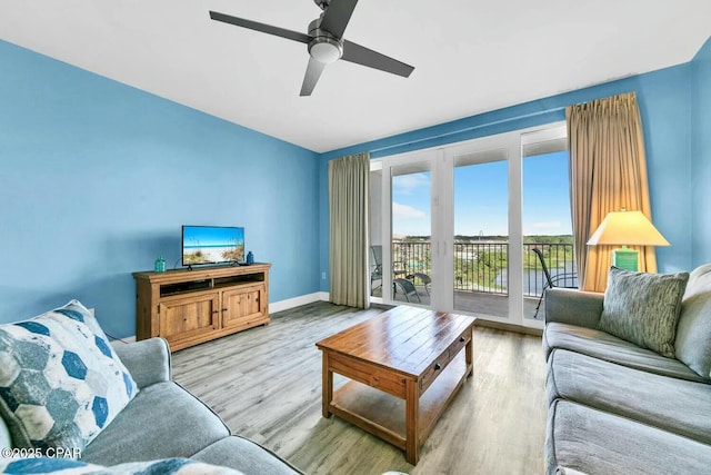 living room with light hardwood / wood-style flooring and ceiling fan