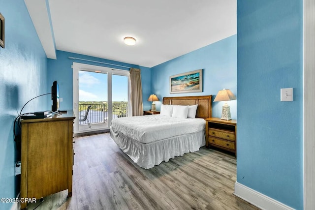 bedroom with wood-type flooring and access to exterior