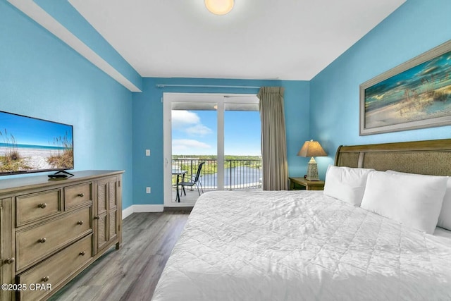 bedroom with a water view, access to exterior, and light hardwood / wood-style flooring