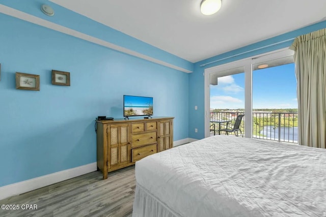 bedroom featuring hardwood / wood-style floors, multiple windows, and access to outside