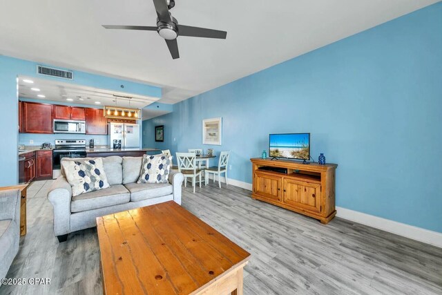 living room with ceiling fan and light hardwood / wood-style floors