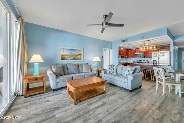 living room featuring light hardwood / wood-style flooring and ceiling fan